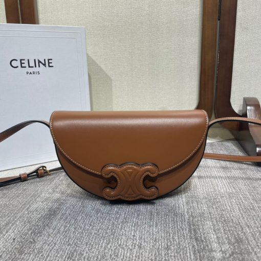CELINE Besace Cuir Triomphe. Authentic quality luxury bag crafted in genuine leather comes with authenticity card, dust bag and gift bag. Revamp your style with our half-moon shape bags, featuring an oversized Triomphe logo and a roomy interior for all your essentials.. Presented in the current trendsetting half-moon shape, our significantly wider format measures 23 cm from tip to tip. Each bag effortlessly opens with a snap button closure, revealing a spacious interior compartment and a convenient flat inner pocket. One notable feature of the bag is the oversized Triomphe logo, showcased with contrasting Tan leather against the Triomphe Canvas. Tonal stitching along the edges adds a refined touch. To achieve a stylish monochrome effect, choose the Ice Blue and Tan option, where the logos are elegantly matched in color.
