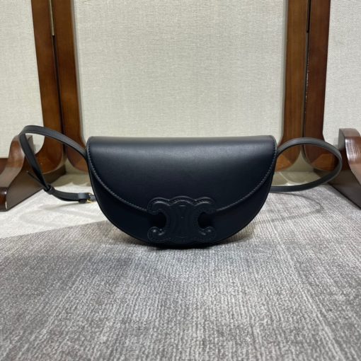 CELINE Besace Cuir Triomphe. Authentic quality luxury bag crafted in genuine leather comes with authenticity card, dust bag and gift bag. Revamp your style with our half-moon shape bags, featuring an oversized Triomphe logo and a roomy interior for all your essentials.. Presented in the current trendsetting half-moon shape, our significantly wider format measures 23 cm from tip to tip. Each bag effortlessly opens with a snap button closure, revealing a spacious interior compartment and a convenient flat inner pocket. One notable feature of the bag is the oversized Triomphe logo, showcased with contrasting Tan leather against the Triomphe Canvas. Tonal stitching along the edges adds a refined touch. To achieve a stylish monochrome effect, choose the Ice Blue and Tan option, where the logos are elegantly matched in color.