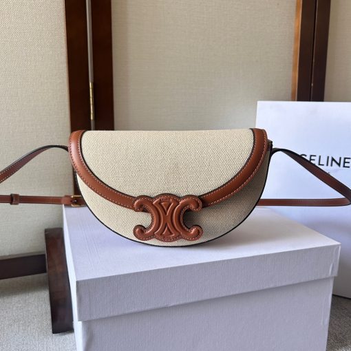 CELINE Besace Cuir Triomphe. Authentic quality luxury bag crafted in genuine leather comes with authenticity card, dust bag and gift bag. Revamp your style with our half-moon shape bags, featuring an oversized Triomphe logo and a roomy interior for all your essentials.. Presented in the current trendsetting half-moon shape, our significantly wider format measures 23 cm from tip to tip. Each bag effortlessly opens with a snap button closure, revealing a spacious interior compartment and a convenient flat inner pocket. One notable feature of the bag is the oversized Triomphe logo, showcased with contrasting Tan leather against the Triomphe Canvas. Tonal stitching along the edges adds a refined touch. To achieve a stylish monochrome effect, choose the Ice Blue and Tan option, where the logos are elegantly matched in color.