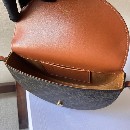 CELINE Besace Cuir Triomphe. Authentic quality luxury bag crafted in genuine leather comes with authenticity card, dust bag and gift bag. Revamp your style with our half-moon shape bags, featuring an oversized Triomphe logo and a roomy interior for all your essentials.. Presented in the current trendsetting half-moon shape, our significantly wider format measures 23 cm from tip to tip. Each bag effortlessly opens with a snap button closure, revealing a spacious interior compartment and a convenient flat inner pocket. One notable feature of the bag is the oversized Triomphe logo, showcased with contrasting Tan leather against the Triomphe Canvas. Tonal stitching along the edges adds a refined touch. To achieve a stylish monochrome effect, choose the Ice Blue and Tan option, where the logos are elegantly matched in color.