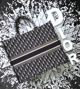 DIOR Book Tote DIOR Oblique Canvas Bag. Authentic quality luxury bag crafted in genuine leather comes with authenticity card, dust bag and gift bag. Inspired by Heritage, Designed for the Future. Inspired by a beautiful drawing created by Marc Bohan in 1967, Maria Grazia Chiuri delved into the esteemed Dior House archives to unveil the magnificent Dior Book Tote as part of the brand's exquisite Spring/Summer 2018 collection. - KRIS + KIKO DIOR Book Tote DIOR Oblique Canvas Bag. High Quality Bag. Original quality DIOR Oblique Jacquard. DIOR Sales Box and Dust Bag. Booklet, Authenticity Card, Payment Slip. Introduced for the brand’s Spring/Summer 2018 collection, Maria Grazia Chiuri immersed herself in Dior House archives to find inspiration from a drawing produced by Marc Bohan in 1967 to create the Dior Book Tote.