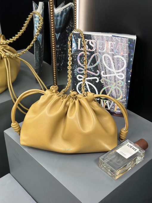 LOEWE Medium Flamenco Purse. Authentic quality luxury bag crafted in genuine leather comes with authenticity card, dust bag and gift bag. Elegant Sophistication. Meet the Flamenco Purse – where timeless style meets modern elegance. Defined by its beautifully ruched design and signature side knots, this medium-sized bag is crafted from soft, supple nappa lambskin. It's the perfect blend of luxurious texture and sophisticated detailing, making it an essential accessory for any wardrobe.