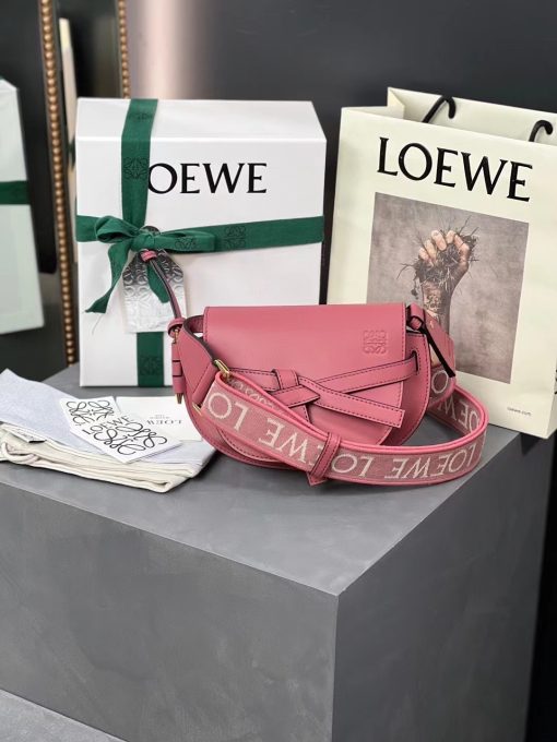 LOEWE Mini Gate Dual Bag. Authentic quality luxury bag crafted in genuine leather comes with authenticity card, dust bag and gift bag. Discover the Art of Leather: Elevate your Style. Exquisitely designed with utmost precision, the Mini Gate Dual showcases LOEWE's unparalleled expertise in leatherwork, enveloped in supple calfskin. Its distinctive features include a meticulously saddle-stitched knotted leather strap and a side-latched metal pin, from which the bag derives its name. Moreover, this miniature rendition is equipped with a removable shoulder strap, also rendered in calfskin, embellished with a repeated LOEWE pattern crafted in jacquard.
