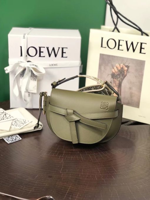 LOEWE Mini Gate Dual Bag. Authentic quality luxury bag crafted in genuine leather comes with authenticity card, dust bag and gift bag. Discover the Art of Leather: Elevate your Style. Exquisitely designed with utmost precision, the Mini Gate Dual showcases LOEWE's unparalleled expertise in leatherwork, enveloped in supple calfskin. Its distinctive features include a meticulously saddle-stitched knotted leather strap and a side-latched metal pin, from which the bag derives its name. Moreover, this miniature rendition is equipped with a removable shoulder strap, also rendered in calfskin, embellished with a repeated LOEWE pattern crafted in jacquard.