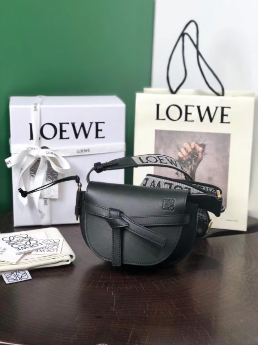 LOEWE Mini Gate Dual Bag. Authentic quality luxury bag crafted in genuine leather comes with authenticity card, dust bag and gift bag. Discover the Art of Leather: Elevate your Style. Exquisitely designed with utmost precision, the Mini Gate Dual showcases LOEWE's unparalleled expertise in leatherwork, enveloped in supple calfskin. Its distinctive features include a meticulously saddle-stitched knotted leather strap and a side-latched metal pin, from which the bag derives its name. Moreover, this miniature rendition is equipped with a removable shoulder strap, also rendered in calfskin, embellished with a repeated LOEWE pattern crafted in jacquard.