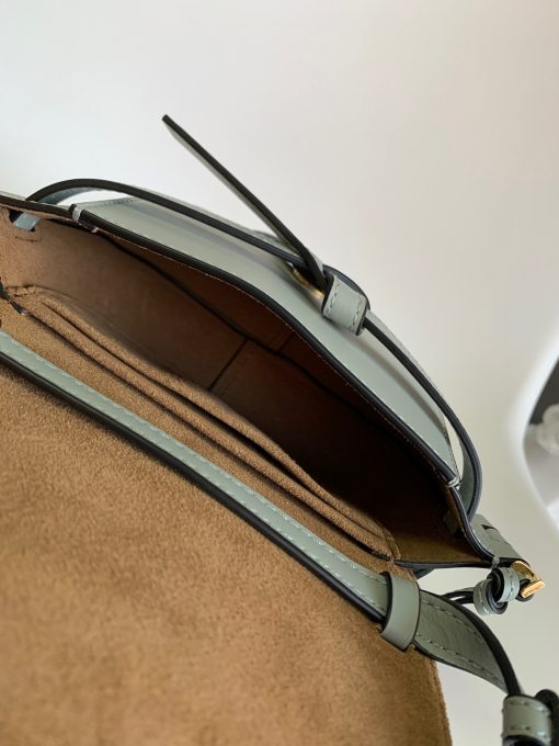 LOEWE Mini Gate Dual Bag. Authentic quality luxury bag crafted in genuine leather comes with authenticity card, dust bag and gift bag. Discover the Art of Leather: Elevate your Style. Exquisitely designed with utmost precision, the Mini Gate Dual showcases LOEWE's unparalleled expertise in leatherwork, enveloped in supple calfskin. Its distinctive features include a meticulously saddle-stitched knotted leather strap and a side-latched metal pin, from which the bag derives its name. Moreover, this miniature rendition is equipped with a removable shoulder strap, also rendered in calfskin, embellished with a repeated LOEWE pattern crafted in jacquard.