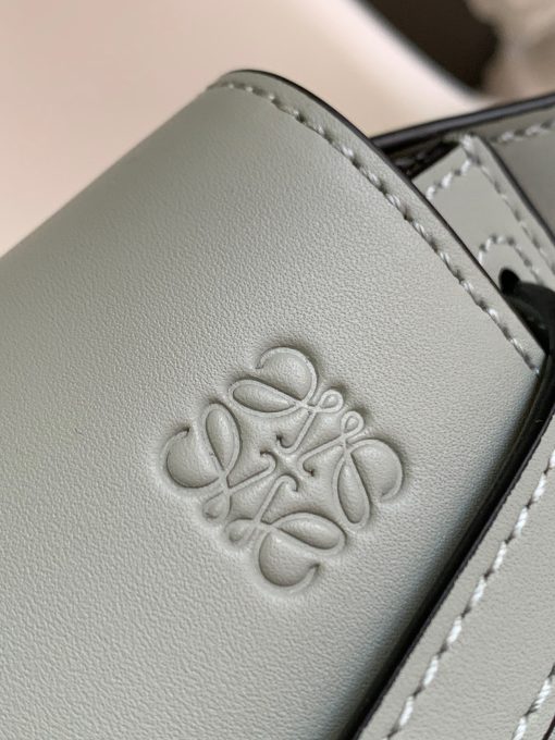 LOEWE Mini Gate Dual Bag. Authentic quality luxury bag crafted in genuine leather comes with authenticity card, dust bag and gift bag. Discover the Art of Leather: Elevate your Style. Exquisitely designed with utmost precision, the Mini Gate Dual showcases LOEWE's unparalleled expertise in leatherwork, enveloped in supple calfskin. Its distinctive features include a meticulously saddle-stitched knotted leather strap and a side-latched metal pin, from which the bag derives its name. Moreover, this miniature rendition is equipped with a removable shoulder strap, also rendered in calfskin, embellished with a repeated LOEWE pattern crafted in jacquard.