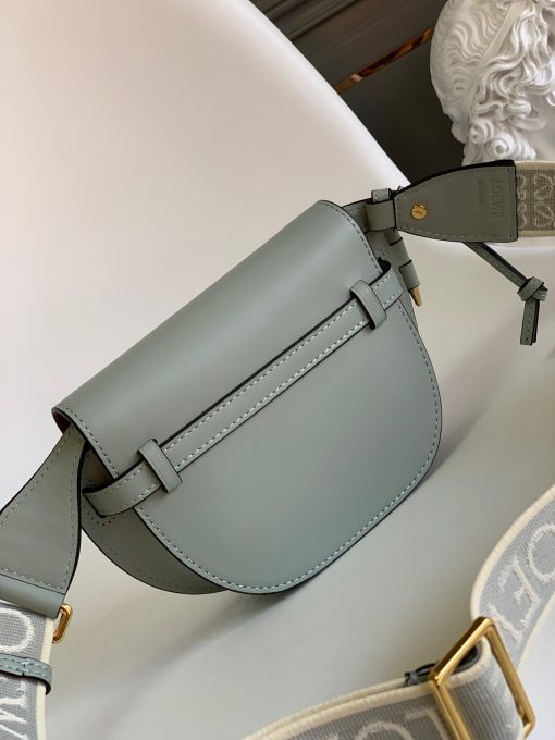 LOEWE Mini Gate Dual Bag. Authentic quality luxury bag crafted in genuine leather comes with authenticity card, dust bag and gift bag. Discover the Art of Leather: Elevate your Style. Exquisitely designed with utmost precision, the Mini Gate Dual showcases LOEWE's unparalleled expertise in leatherwork, enveloped in supple calfskin. Its distinctive features include a meticulously saddle-stitched knotted leather strap and a side-latched metal pin, from which the bag derives its name. Moreover, this miniature rendition is equipped with a removable shoulder strap, also rendered in calfskin, embellished with a repeated LOEWE pattern crafted in jacquard.