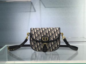 DIOR Small Bobby Bag. Authentic quality luxury bag crafted in genuine leather comes with authenticity card, dust bag and gift bag. Functionality Meets Elegance in Perfect Harmony. Maria Grazia Chiuri has introduced a new addition to the prestigious French fashion house's collection of iconic bags: the Dior Bobby. This stylish bag pays tribute to the owner's beloved pet pooch and showcases a new silhouette that resembles the D-fence bag, featuring the timeless CD logo. The Dior Bobby is the epitome of functionality and elegance, providing the perfect size for fashionable individuals who want to make a statement. With its practical shoulder strap, this sassy bag is perfectly suited to meet the demands of modern life. Its feminine curves and discreet "30 Montaigne" inscription on the back serve as a gentle nod to the renowned symbolic bag that shares its name. - KRIS + KIKO DIOR Small Bobby Bag. Original Quality Bag, including gift box, literature, dust bag, authenticity card. Maria Grazia Chiuri introduced a new silhouette to the French fashion house’s repertoire of It bags: the Dior Bobby which pays homage to the lovely pooch of the master himself. The Dior Bobby is a rounded flap that is similar to the D-fence bag with the classic CD logo. Got to admit, Bobby offers the best size for a bag that’s meant to be functional, easy to strut around in while looking like a million bucks. The Dior Bobby is a sassy shoulder bag that’s well suited for today’s call for practicality. Its feminine curve and the ‘30 Montaigne’ address on the back, renders a subtle echo of the eponymous symbolic bag.