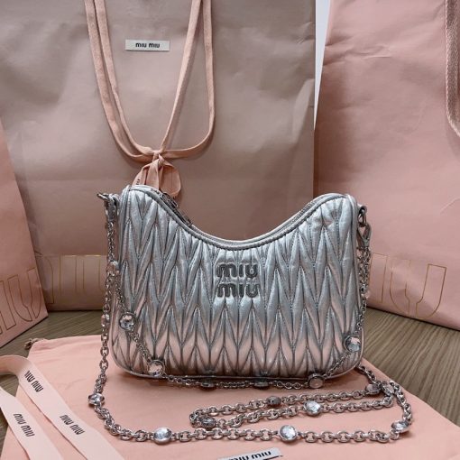 MIU MIU Matelassé Shoulder Bag. Authentic quality luxury bag crafted in genuine leather comes with authenticity card, dust bag and gift bag. Elevate your style with sophistication and craftsmanship. The exquisite matelassé technique exudes elegance and creates a visually captivating, multi-dimensional effect on this nappa leather shoulder bag. The beautifully crafted logo, reflecting the various metallic finishes of the hardware, effortlessly catches the eye, adding a touch of distinction to the immaculate artisanal work. Both functional and aesthetically pleasing, the detachable chain and leather shoulder straps perfectly meet your needs.