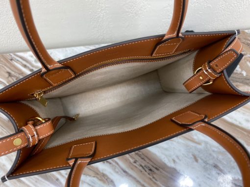 CELINE Cabas Triomphe Mini. Authentic quality luxury bag crafted in genuine leather comes with authenticity card, dust bag and gift bag. Elegance Meets Iconic Design The Triomphe bag initially had a lukewarm reception, but it is now steadily gaining attention and recognition. The origins of its story can be traced back to the stunning CELINE Triomphe bag, which pays homage to the iconic Arc de Triomphe. Embarking on a new chapter, CELINE has crafted an entire collection dedicated to the Triomphe line. This collection comprises a tote bag, bucket bag, camera bag, drawstring bag, and a Boston bag, all meticulously crafted from Triomphe canvas adorned with exquisite calfskin trimming.