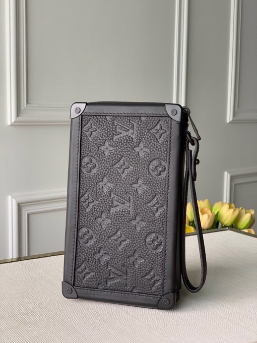 LOUIS VUITTON Soft Trunk Clutch. Authentic quality luxury bag crafted in genuine leather comes with authenticity card, dust bag and gift bag. Practical elegance for the modern gentleman. Introducing the sleek Soft Trunk Clutch designed specifically for men. Meticulously crafted from luxurious black Taurillon leather, this exquisite accessory features an embossed Monogram pattern. Boasting a refined rectilinear form and compact dimensions, it effortlessly accommodates your essential items such as a phone, earbuds, and credit cards. With a wide zipped opening for easy access and a removable wristband, it provides utmost practicality and convenience.