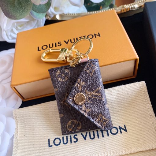 LOUIS VUITTON Kirigami Pouch Bag Charm & Key Holder. Authentic quality luxury accessory crafted in genuine leather comes with authenticity card, dust bag and gift bag. Exquisite Practicality, Perfected Elegance. The pouch bag charm and key holder effortlessly combine practicality and elegance. The design showcases the iconic Monogram canvas, adding a touch of versatility. With a functional pouch that opens through a convenient snap button, every detail is flawlessly crafted. Inside, a luxurious suede lining awaits, complemented by House emblems like the LV Circle charm and signature engraving, adding a distinctive touch.