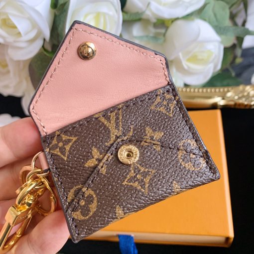 LOUIS VUITTON Kirigami Pouch Bag Charm & Key Holder. Authentic quality luxury accessory crafted in genuine leather comes with authenticity card, dust bag and gift bag. Exquisite Practicality, Perfected Elegance. The pouch bag charm and key holder effortlessly combine practicality and elegance. The design showcases the iconic Monogram canvas, adding a touch of versatility. With a functional pouch that opens through a convenient snap button, every detail is flawlessly crafted. Inside, a luxurious suede lining awaits, complemented by House emblems like the LV Circle charm and signature engraving, adding a distinctive touch.