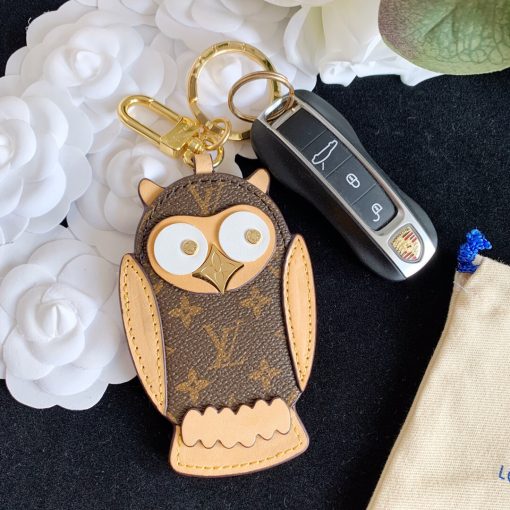 LOUIS VUITTON Owl Bag-Charm & Key Holder. Authentic quality luxury accessory crafted in genuine leather comes with authenticity card, dust bag and gift bag. Embrace whimsical elegance. The Owl bag charm and key holder showcases a lively mascot, adorned with LV stud eyes and a Monogram Flower beak. This charming accessory combines gold-color hardware, expertly blending calf leather and Monogram Eclipse canvas - both iconic materials of the House. The refined hook and ring are exquisitely engraved with the LOUIS VUITTON signature, adding an elegant touch to its overall design.