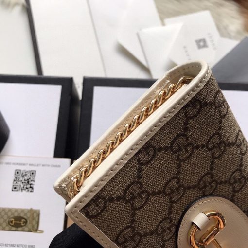 GUCCI 1955 GG Supreme Horsebit Wallet On Chain. Authentic quality luxury bag crafted in genuine leather comes with authenticity card, dust bag and gift bag. Unlock the essence of timeless elegance. Introducing the chain wallet from Gucci's esteemed Horsebit 1955 accessories collection, crafted with GG Supreme canvas and leather. This exquisite piece showcases the iconic double ring and bar design found in their esteemed Handbags line. The wallet's sleek snap-closure shape reveals numerous card slots and pockets, offering practicality alongside style. Furthermore, it boasts a detachable chain strap, adding versatility to its elegant design.