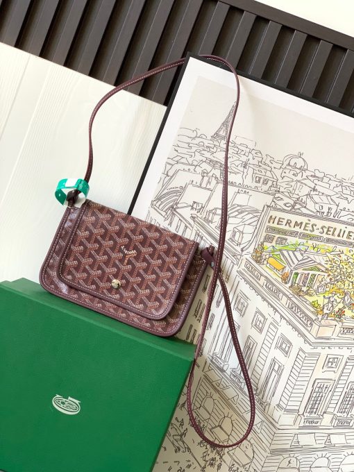 GOYARD Plumet Pocket Wallet. Authentic quality luxury bag crafted in genuine leather comes with authenticity card, dust bag and gift bag. Parisian Elegance Meets Functional Versatility. The Plumet pocket wallet derives its inspiration from the exquisite pocket featured in the Saint Louis bag. Paying a heartfelt tribute to the industrious laborers of Paris's vibrant ports, who skillfully navigated rafts to their destinations along the picturesque banks of the River Seine, this wallet seamlessly blends form and function. Crafted with dedicated compartments for coins, bills, and cards, the Plumet pocket wallet boasts a versatile design. It can be effortlessly worn across the chest, transforming into a chic miniature bag with the convenience of its removable strap. With its three distinct pockets, it gracefully accommodates its contents, adapting with elegance to your everyday needs.