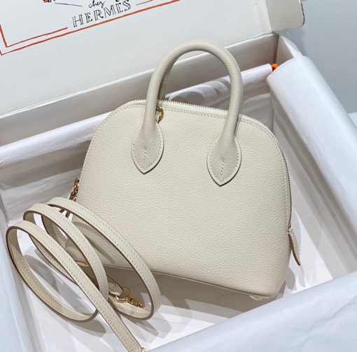 HERMÈS Bolide 1923 Mini. Authentic quality luxury bag crafted in genuine leather comes with authenticity card, dust bag and gift bag. Timeless Elegance, Unparalleled Convenience: The Bolide Bag – A Journey in Every Stitch. Created in 1923 with the discerning needs of elite drivers and seasoned long-distance travelers in mind, this globe-trotting bag effortlessly finds its place within any automobile trunk. Its iconic round-angled shape owes its origins to the zip fastener, a novel invention introduced to France by Émile Hermès in the late 1910s, and this innovative feature enables swift access to its contents. The Bolide bag is available in various sizes, including a travel-sized version, and a range of handbag options, offering both style and functionality to its fortunate owners.