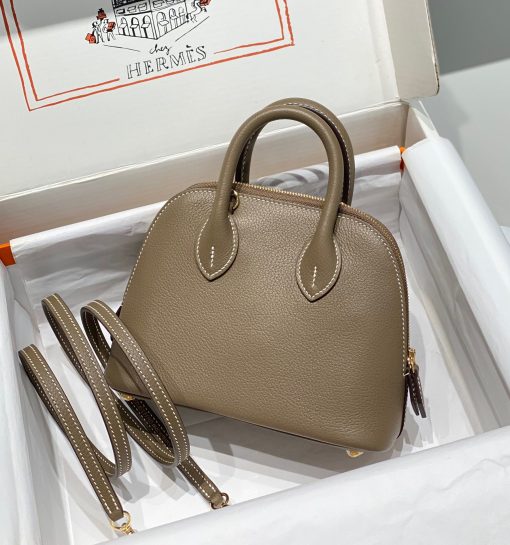 HERMÈS Bolide 1923 Mini. Authentic quality luxury bag crafted in genuine leather comes with authenticity card, dust bag and gift bag. Timeless Elegance, Unparalleled Convenience: The Bolide Bag – A Journey in Every Stitch. Created in 1923 with the discerning needs of elite drivers and seasoned long-distance travelers in mind, this globe-trotting bag effortlessly finds its place within any automobile trunk. Its iconic round-angled shape owes its origins to the zip fastener, a novel invention introduced to France by Émile Hermès in the late 1910s, and this innovative feature enables swift access to its contents. The Bolide bag is available in various sizes, including a travel-sized version, and a range of handbag options, offering both style and functionality to its fortunate owners.