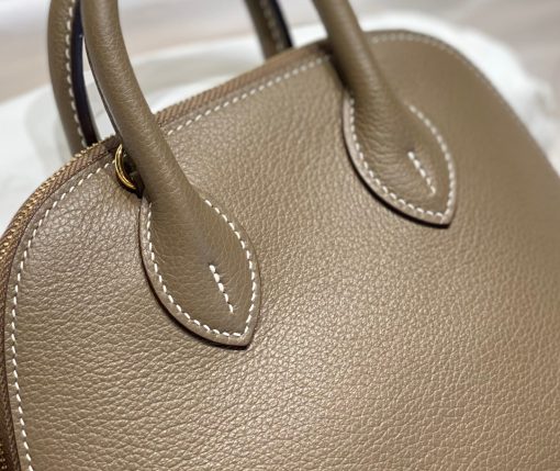 HERMÈS Bolide 1923 Mini. Authentic quality luxury bag crafted in genuine leather comes with authenticity card, dust bag and gift bag. Timeless Elegance, Unparalleled Convenience: The Bolide Bag – A Journey in Every Stitch. Created in 1923 with the discerning needs of elite drivers and seasoned long-distance travelers in mind, this globe-trotting bag effortlessly finds its place within any automobile trunk. Its iconic round-angled shape owes its origins to the zip fastener, a novel invention introduced to France by Émile Hermès in the late 1910s, and this innovative feature enables swift access to its contents. The Bolide bag is available in various sizes, including a travel-sized version, and a range of handbag options, offering both style and functionality to its fortunate owners.