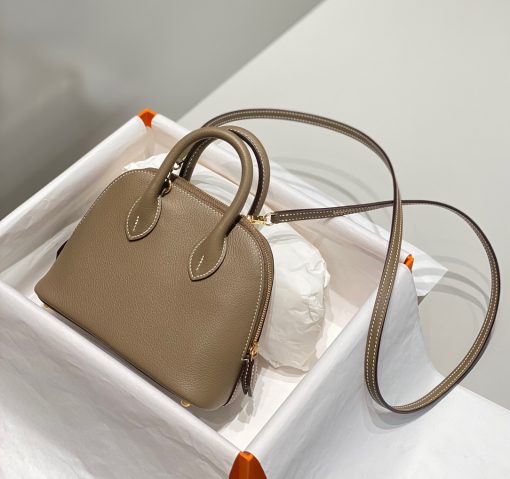 HERMÈS Bolide 1923 Mini. Authentic quality luxury bag crafted in genuine leather comes with authenticity card, dust bag and gift bag. Timeless Elegance, Unparalleled Convenience: The Bolide Bag – A Journey in Every Stitch. Created in 1923 with the discerning needs of elite drivers and seasoned long-distance travelers in mind, this globe-trotting bag effortlessly finds its place within any automobile trunk. Its iconic round-angled shape owes its origins to the zip fastener, a novel invention introduced to France by Émile Hermès in the late 1910s, and this innovative feature enables swift access to its contents. The Bolide bag is available in various sizes, including a travel-sized version, and a range of handbag options, offering both style and functionality to its fortunate owners.