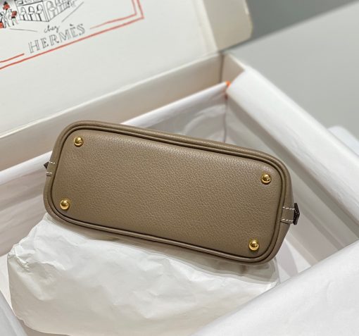 HERMÈS Bolide 1923 Mini. Authentic quality luxury bag crafted in genuine leather comes with authenticity card, dust bag and gift bag. Timeless Elegance, Unparalleled Convenience: The Bolide Bag – A Journey in Every Stitch. Created in 1923 with the discerning needs of elite drivers and seasoned long-distance travelers in mind, this globe-trotting bag effortlessly finds its place within any automobile trunk. Its iconic round-angled shape owes its origins to the zip fastener, a novel invention introduced to France by Émile Hermès in the late 1910s, and this innovative feature enables swift access to its contents. The Bolide bag is available in various sizes, including a travel-sized version, and a range of handbag options, offering both style and functionality to its fortunate owners.