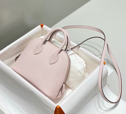 HERMÈS Bolide 1923 Mini. Authentic quality luxury bag crafted in genuine leather comes with authenticity card, dust bag and gift bag. Timeless Elegance, Unparalleled Convenience: The Bolide Bag – A Journey in Every Stitch. Created in 1923 with the discerning needs of elite drivers and seasoned long-distance travelers in mind, this globe-trotting bag effortlessly finds its place within any automobile trunk. Its iconic round-angled shape owes its origins to the zip fastener, a novel invention introduced to France by Émile Hermès in the late 1910s, and this innovative feature enables swift access to its contents. The Bolide bag is available in various sizes, including a travel-sized version, and a range of handbag options, offering both style and functionality to its fortunate owners.