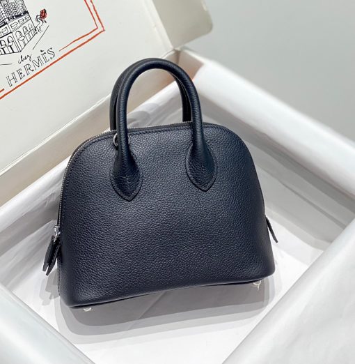 HERMÈS Bolide 1923 Mini. Authentic quality luxury bag crafted in genuine leather comes with authenticity card, dust bag and gift bag. Timeless Elegance, Unparalleled Convenience: The Bolide Bag – A Journey in Every Stitch. Created in 1923 with the discerning needs of elite drivers and seasoned long-distance travelers in mind, this globe-trotting bag effortlessly finds its place within any automobile trunk. Its iconic round-angled shape owes its origins to the zip fastener, a novel invention introduced to France by Émile Hermès in the late 1910s, and this innovative feature enables swift access to its contents. The Bolide bag is available in various sizes, including a travel-sized version, and a range of handbag options, offering both style and functionality to its fortunate owners.