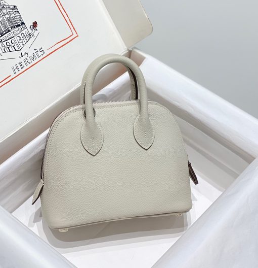 HERMÈS Bolide 1923 Mini. Authentic quality luxury bag crafted in genuine leather comes with authenticity card, dust bag and gift bag. Timeless Elegance, Unparalleled Convenience: The Bolide Bag – A Journey in Every Stitch. Created in 1923 with the discerning needs of elite drivers and seasoned long-distance travelers in mind, this globe-trotting bag effortlessly finds its place within any automobile trunk. Its iconic round-angled shape owes its origins to the zip fastener, a novel invention introduced to France by Émile Hermès in the late 1910s, and this innovative feature enables swift access to its contents. The Bolide bag is available in various sizes, including a travel-sized version, and a range of handbag options, offering both style and functionality to its fortunate owners.