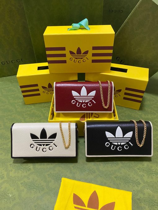 GUCCI Wallet With Chain. Authentic quality luxury bag crafted in genuine leather comes with authenticity card, dust bag and gift bag. Reviving the past, redefining the future: GUCCI X ADIDAS - Uniting heritage and innovation in one iconic collection. Introducing a remarkable addition from the GUCCI X ADIDAS collection: a chain wallet adorned with the iconic Gucci Trefoil print. This special collaboration intertwines the distinctive motifs of Gucci and the esteemed sportswear brand adidas, encapsulating their legacies within a trilogy of exquisite designs. Under the visionary guidance of Creative Director Alessandro Michele, who draws inspiration from cherished recollections of the vibrant '80s and '90s, this collection effortlessly merges nostalgia with modernity, resulting in a truly timeless masterpiece.