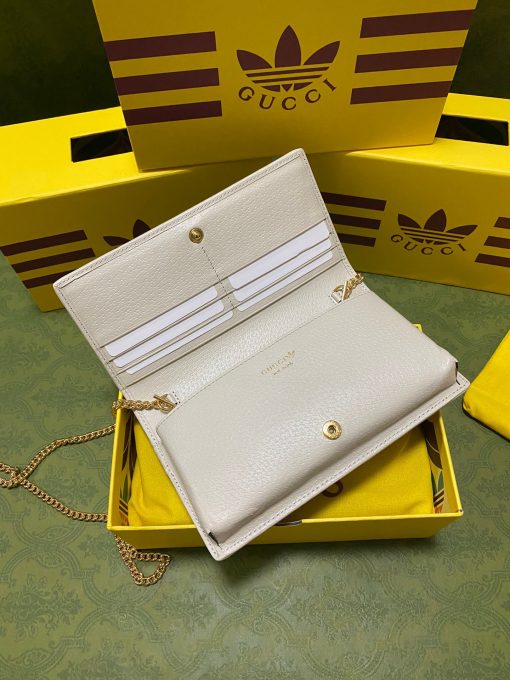 GUCCI Wallet With Chain. Authentic quality luxury bag crafted in genuine leather comes with authenticity card, dust bag and gift bag. Reviving the past, redefining the future: GUCCI X ADIDAS - Uniting heritage and innovation in one iconic collection. Introducing a remarkable addition from the GUCCI X ADIDAS collection: a chain wallet adorned with the iconic Gucci Trefoil print. This special collaboration intertwines the distinctive motifs of Gucci and the esteemed sportswear brand adidas, encapsulating their legacies within a trilogy of exquisite designs. Under the visionary guidance of Creative Director Alessandro Michele, who draws inspiration from cherished recollections of the vibrant '80s and '90s, this collection effortlessly merges nostalgia with modernity, resulting in a truly timeless masterpiece.