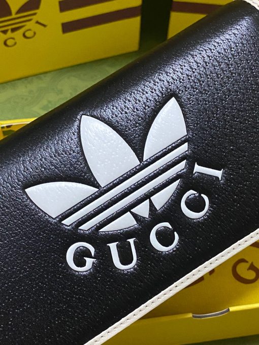 GUCCI Wallet With Chain. Authentic quality luxury bag crafted in genuine leather comes with authenticity card, dust bag and gift bag. Reviving the past, redefining the future: GUCCI X ADIDAS - Uniting heritage and innovation in one iconic collection. Introducing a remarkable addition from the GUCCI X ADIDAS collection: a chain wallet adorned with the iconic Gucci Trefoil print. This special collaboration intertwines the distinctive motifs of Gucci and the esteemed sportswear brand adidas, encapsulating their legacies within a trilogy of exquisite designs. Under the visionary guidance of Creative Director Alessandro Michele, who draws inspiration from cherished recollections of the vibrant '80s and '90s, this collection effortlessly merges nostalgia with modernity, resulting in a truly timeless masterpiece.