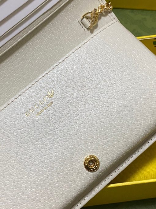 GUCCI Wallet With Chain. Authentic quality luxury bag crafted in genuine leather comes with authenticity card, dust bag and gift bag. Reviving the past, redefining the future: GUCCI X ADIDAS - Uniting heritage and innovation in one iconic collection. Introducing a remarkable addition from the GUCCI X ADIDAS collection: a chain wallet adorned with the iconic Gucci Trefoil print. This special collaboration intertwines the distinctive motifs of Gucci and the esteemed sportswear brand adidas, encapsulating their legacies within a trilogy of exquisite designs. Under the visionary guidance of Creative Director Alessandro Michele, who draws inspiration from cherished recollections of the vibrant '80s and '90s, this collection effortlessly merges nostalgia with modernity, resulting in a truly timeless masterpiece.
