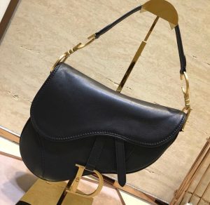 DIOR Saddle Shoulder Bag. Authentic quality luxury bag crafted in genuine leather comes with authenticity card, dust bag and gift bag. Equestrian-inspired luxury, crafted for timeless style. It was originally introduced by designer John Galliano in the late 1990s and has since become an iconic accessory in the fashion world. The bag features a unique curved shape resembling a horse saddle, hence the name. It is crafted from high-quality materials such as smooth calfskin or the classic Dior Oblique canvas, and often adorned with the brand's signature logo hardware. The bag can be worn crossbody or over the shoulder, offering versatility and functionality. With its timeless design and elegant aesthetic, the DIOR Saddle Shoulder Bag has gained a cult following and remains a coveted item among fashion enthusiasts. - KRIS + KIKO DIOR Saddle Shoulder Bag. Original Quality Bag. Authentic Style. Genuine Calf Leather. Metal Hardware. Authentic Packaging. Original Quality Dust Bag.