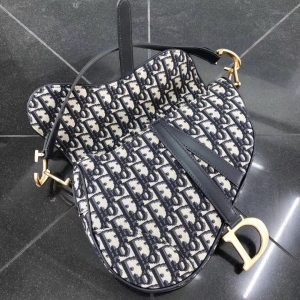 DIOR Saddle Shoulder Bag. Authentic quality luxury bag crafted in genuine leather comes with authenticity card, dust bag and gift bag. Equestrian-inspired luxury, crafted for timeless style. It was originally introduced by designer John Galliano in the late 1990s and has since become an iconic accessory in the fashion world. The bag features a unique curved shape resembling a horse saddle, hence the name. It is crafted from high-quality materials such as smooth calfskin or the classic Dior Oblique canvas, and often adorned with the brand's signature logo hardware. The bag can be worn crossbody or over the shoulder, offering versatility and functionality. With its timeless design and elegant aesthetic, the DIOR Saddle Shoulder Bag has gained a cult following and remains a coveted item among fashion enthusiasts. - KRIS + KIKO DIOR Saddle Shoulder Bag. Original Quality Bag. Authentic Style. Genuine Calf Leather. Metal Hardware. Authentic Packaging. Original Quality Dust Bag.