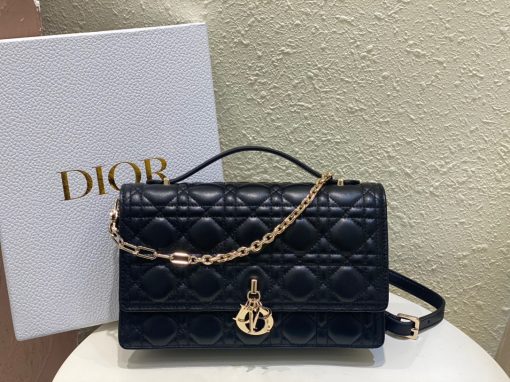 DIOR Miss Dior Top Handle Bag. Authentic quality luxury bag crafted in genuine leather comes with authenticity card, dust bag and gift bag. Your Day to Evening Essential. Elegance in Every Detail. Introducing the latest addition to the Cruise 2024 collection, the Miss Dior Top Handle bag embodies an exquisite blend of sophistication and functionality. Meticulously fashioned from luxurious black lambskin adorned with meticulous Cannage stitching, this bag showcases a gracefully adorned flap adorned by a captivating D.I.O.R. charm. Beneath this flap, you'll discover two spacious compartments and a secure zipped pouch, designed to effortlessly accommodate all your essentials, whether it's day or night. The signature Top Handle of this bag is both elegant and versatile, featuring a removable chain strap with a leather insert. This thoughtful design allows you to carry it comfortably in hand, wear it gracefully over your shoulder, or effortlessly sling it across your body for a stylish and adaptable look.