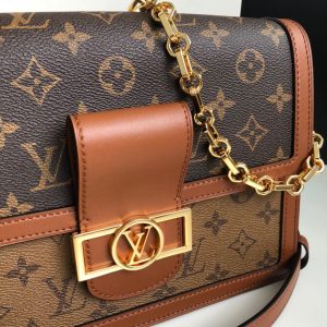 LOUIS VUITTON Dauphine MM Shoulder Bag. Authentic quality luxury bag crafted in genuine leather comes with authenticity card, dust bag and gift bag. A Modern Must-Have. Nicolas Ghesquière presents a captivating addition to the Spring-Summer 2019 collection: the Dauphine Mini handbag. This charming and sleek design is exquisitely crafted using Monogram and Monogram Reverse canvas, elegantly accentuated with smooth tan calfskin trim. The striking LV lock and leather smart strap bring a contemporary touch to this iconic piece, perfectly sized for seamless transitions from day to night. - KRIS + KIKO LOUS VUITTON Dauphine MM Shoulder Bag. Original Quality Bag. Authentic Style. Genuine Calf Leather. Metal Hardware. Authentic Packaging. Original Quality Dust Bag. For Spring-Summer 2019 Nicolas Ghesquière unveils a new must-have: the Dauphine Mini handbag. This adorable compact model is crafted from Monogram and Monogram Reverse canvas, trimmed with smooth tan calfskin. The high-shine LV lock and leather smart strap add a modern twist to this signature piece, which is perfectly sized for day-to-evening wear.
