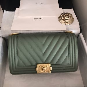 CHANEL Chevron Quilted Leather Flap Bag. Authentic quality luxury bag crafted in genuine leather comes with authenticity card, dust bag and gift bag. A love story in every stitch. The Chanel Boy Flap Bag Quilted is an exquisite creation by the renowned Karl Lagerfeld, paying homage to Gabrielle Chanel's beloved Boy Capel. This iconic design truly represents every woman's ultimate aspiration. Meticulously crafted from high-quality calfskin leather, this bag showcases Chanel's distinctive chevron quilting, complemented by a striking chunky chain link strap adorned with a leather shoulder pad and elegant metal-tone hardware accents. Opening with a captivating CC Boy logo closure, its fabric-lined interior includes a convenient slip pocket, ideal for organizing daily essentials. With its undeniable allure, this sought-after accessory is a luxurious must-have. - KRIS + KIKO CHANEL Chevron Quilted Leather Flap Bag. Authentic quality luxury bag crafted in genuine leather comes with authenticity card, dust bag and gift bag. A love story in every stitch. The Chanel Boy Flap Bag Quilted is an exquisite creation by the renowned Karl Lagerfeld, paying homage to Gabrielle Chanel's beloved Boy Capel. This iconic design truly represents every woman's ultimate aspiration. Meticulously crafted from high-quality calfskin leather, this bag showcases Chanel's distinctive chevron quilting, complemented by a striking chunky chain link strap adorned with a leather shoulder pad and elegant metal-tone hardware accents. Opening with a captivating CC Boy logo closure, its fabric-lined interior includes a convenient slip pocket, ideal for organizing daily essentials. With its undeniable allure, this sought-after accessory is a luxurious must-have.