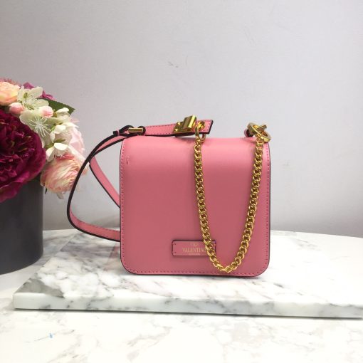 VALENTINO VSling Mini Leather Shoulder Bag. Authentic quality luxury bag crafted in genuine leather comes with authenticity card, dust bag and gift bag. Elegance Meets Functionality. VALENTINO's SS20 accessories collection showcases their new V Ring logo, which has left us completely captivated. Pierpaolo Picciolil's attention to clean lines and thoughtful details is evident in this exquisite orange leather V-logo bag. The adjustable cross-body strap adds functionality to its elegance, while the iconic logo plaque graces the front flap. Inside, a black leather interior with a convenient slip pocket awaits. For a chic ensemble, pair it with a blouse tucked into a midi skirt and wear it gracefully over your shoulder.