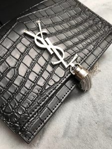 SAINT LAURENT Small 'Kate' Bag with Tassel. Authentic quality luxury bag crafted in genuine leather comes with authenticity card, dust bag and gift bag. Discover the epitome of elegance. Elegantly designed, the Monogram SAINT LAURENT bag is embellished with a sleek curb chain, interlocking YSL initials in metal, and a shimmering metallic tassel. Meticulously crafted from supple leather, the Kate shoulder bag by Saint Laurent showcases a distinctive YSL monogram plaque and a dangling tassel detail on the front, adding an exquisite touch. This exquisite accessory is ideal for a night out, serving as the perfect go-to option. It features a chain shoulder strap, a secure foldover top with magnetic closure, a spacious main compartment, an internal slip pocket, a logo patch, a logo stamp, and exquisite metal hardware for a sophisticated finish. - KRIS + KIKO SAINT LAURENT Small 'Kate' Bag with Tassel. Authentic quality luxury bag crafted in genuine leather comes with authenticity card, dust bag and gift bag. Discover the epitome of elegance. Elegantly designed, the Monogram SAINT LAURENT bag is embellished with a sleek curb chain, interlocking YSL initials in metal, and a shimmering metallic tassel. Meticulously crafted from supple leather, the Kate shoulder bag by Saint Laurent showcases a distinctive YSL monogram plaque and a dangling tassel detail on the front, adding an exquisite touch. This exquisite accessory is ideal for a night out, serving as the perfect go-to option. It features a chain shoulder strap, a secure foldover top with magnetic closure, a spacious main compartment, an internal slip pocket, a logo patch, a logo stamp, and exquisite metal hardware for a sophisticated finish.