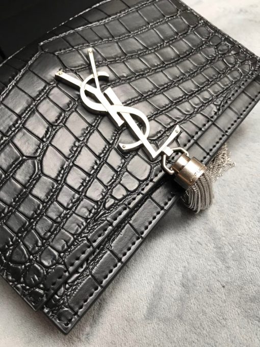 SAINT LAURENT Small 'Kate' Bag with Tassel. Authentic quality luxury bag crafted in genuine leather comes with authenticity card, dust bag and gift bag. Discover the epitome of elegance. Elegantly designed, the Monogram SAINT LAURENT bag is embellished with a sleek curb chain, interlocking YSL initials in metal, and a shimmering metallic tassel. Meticulously crafted from supple leather, the Kate shoulder bag by Saint Laurent showcases a distinctive YSL monogram plaque and a dangling tassel detail on the front, adding an exquisite touch. This exquisite accessory is ideal for a night out, serving as the perfect go-to option. It features a chain shoulder strap, a secure foldover top with magnetic closure, a spacious main compartment, an internal slip pocket, a logo patch, a logo stamp, and exquisite metal hardware for a sophisticated finish.