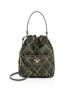 PRADA Quilted Bucket Bag. Authentic quality luxury bag crafted in genuine leather comes with authenticity card, dust bag and gift bag. Elevating Style with Quilted Luxury. Introducing the exquisite PRADA nylon bucket bag, featuring tessuto-impunturato quilted topstitching for a luxurious touch. Designed with a sleek leather top handle, this bag showcases a convenient drawstring top closure for easy access. It also includes a detachable shoulder strap, allowing for versatile carrying options. The front zip pocket, adorned with an elegant logo plate, adds a chic element to this stunning bag. - KRIS + KIKO PRADA Quilted Bucket Bag. Original Quality Bag including gift box, care book, dust bag, authenticity card. PRADA nylon bucket bag with tessuto-impunturato quilted topstitching. Leather top handle. Drawstring top. Detachable Shoulder Strap. Front Zip Pocket with logo plate.