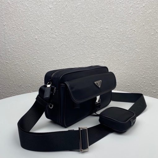 PRADA Nylon Cross-Body Bag. Authentic quality luxury bag crafted in genuine leather comes with authenticity card, dust bag and gift bag. Indulge in Effortless Elegance. This beautifully crafted bag, adorned with luxurious Saffiano leather trim, exudes elegance and sophistication. Its compact size and sleek design make it a perfect choice for any occasion. The distinctive side release buckle on the front adds a touch of uniqueness, while the adjustable shoulder strap ensures comfortable wear. The bag features impeccable details such as metal hardware, the iconic Prada logo lining, a logo tag inside, and an enameled metal triangle logo outside. It offers convenient storage with a spacious main compartment secured by a zipper, a secondary compartment with a flap and side release buckle, and two front pockets, including one with a zipper closure.