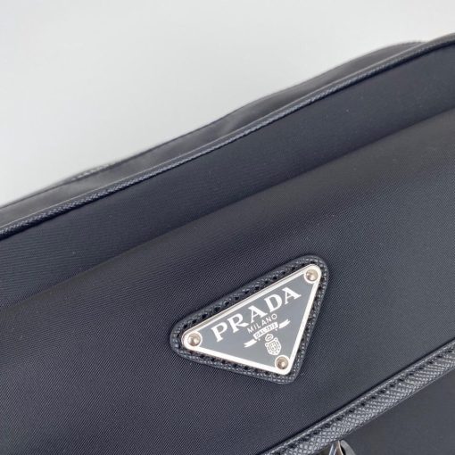 PRADA Nylon Cross-Body Bag. Authentic quality luxury bag crafted in genuine leather comes with authenticity card, dust bag and gift bag. Indulge in Effortless Elegance. This beautifully crafted bag, adorned with luxurious Saffiano leather trim, exudes elegance and sophistication. Its compact size and sleek design make it a perfect choice for any occasion. The distinctive side release buckle on the front adds a touch of uniqueness, while the adjustable shoulder strap ensures comfortable wear. The bag features impeccable details such as metal hardware, the iconic Prada logo lining, a logo tag inside, and an enameled metal triangle logo outside. It offers convenient storage with a spacious main compartment secured by a zipper, a secondary compartment with a flap and side release buckle, and two front pockets, including one with a zipper closure.