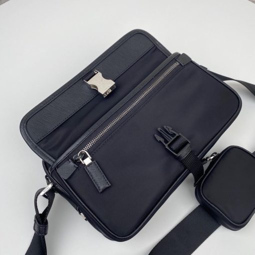 PRADA Nylon Cross-Body Bag. Original Quality Bag including gift box, care book, dust bag, authenticity card. This bag decorated with Saffiano leather trim presents compact volumes and a sleek design. With its distinctive side release buckle on the front, it comes with an easily adjustable shoulder strap. This cross-body bag featuring Saffiano leather trim with metal hardware and Prada logo lining, logo tag inside, enameled metal triangle logo outside. It has a main compartment with zipper, secondary compartment with flap and side release buckle, two front pockets, including one with zipper.