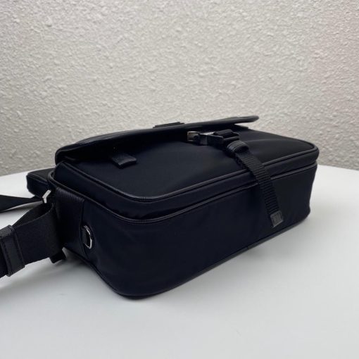 PRADA Nylon Cross-Body Bag. Original Quality Bag including gift box, care book, dust bag, authenticity card. This bag decorated with Saffiano leather trim presents compact volumes and a sleek design. With its distinctive side release buckle on the front, it comes with an easily adjustable shoulder strap. This cross-body bag featuring Saffiano leather trim with metal hardware and Prada logo lining, logo tag inside, enameled metal triangle logo outside. It has a main compartment with zipper, secondary compartment with flap and side release buckle, two front pockets, including one with zipper.