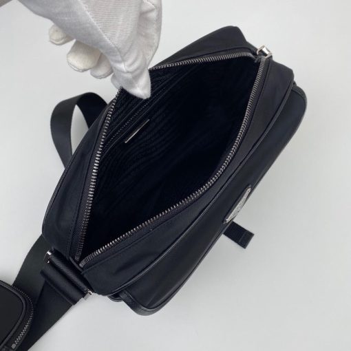 PRADA Nylon Cross-Body Bag. Authentic quality luxury bag crafted in genuine leather comes with authenticity card, dust bag and gift bag. Indulge in Effortless Elegance. This beautifully crafted bag, adorned with luxurious Saffiano leather trim, exudes elegance and sophistication. Its compact size and sleek design make it a perfect choice for any occasion. The distinctive side release buckle on the front adds a touch of uniqueness, while the adjustable shoulder strap ensures comfortable wear. The bag features impeccable details such as metal hardware, the iconic Prada logo lining, a logo tag inside, and an enameled metal triangle logo outside. It offers convenient storage with a spacious main compartment secured by a zipper, a secondary compartment with a flap and side release buckle, and two front pockets, including one with a zipper closure.