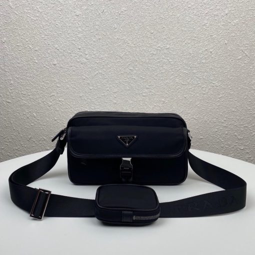 PRADA Nylon Cross-Body Bag. Original Quality Bag including gift box, care book, dust bag, authenticity card. This bag decorated with Saffiano leather trim presents compact volumes and a sleek design. With its distinctive side release buckle on the front, it comes with an easily adjustable shoulder strap. This cross-body bag featuring Saffiano leather trim with metal hardware and Prada logo lining, logo tag inside, enameled metal triangle logo outside. It has a main compartment with zipper, secondary compartment with flap and side release buckle, two front pockets, including one with zipper.