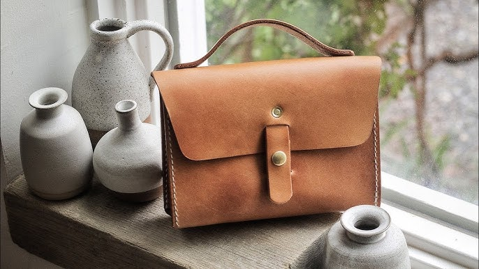 Artisan hands at work crafting a leather bag in a workshop