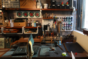 A boutique Chinese leather workshop with tools and leather goods in progress